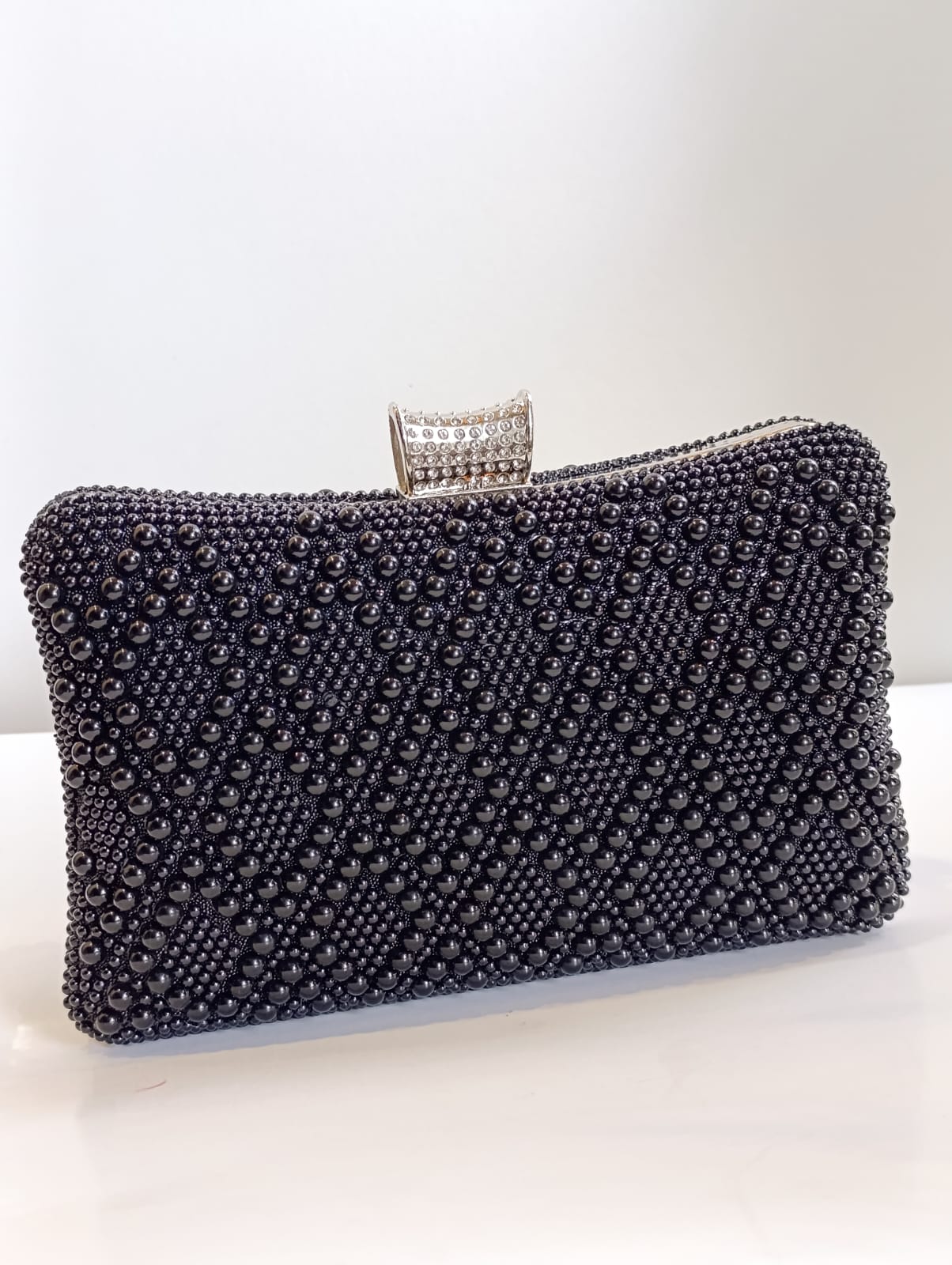 Clutch negro con perlas y cadena desmontable